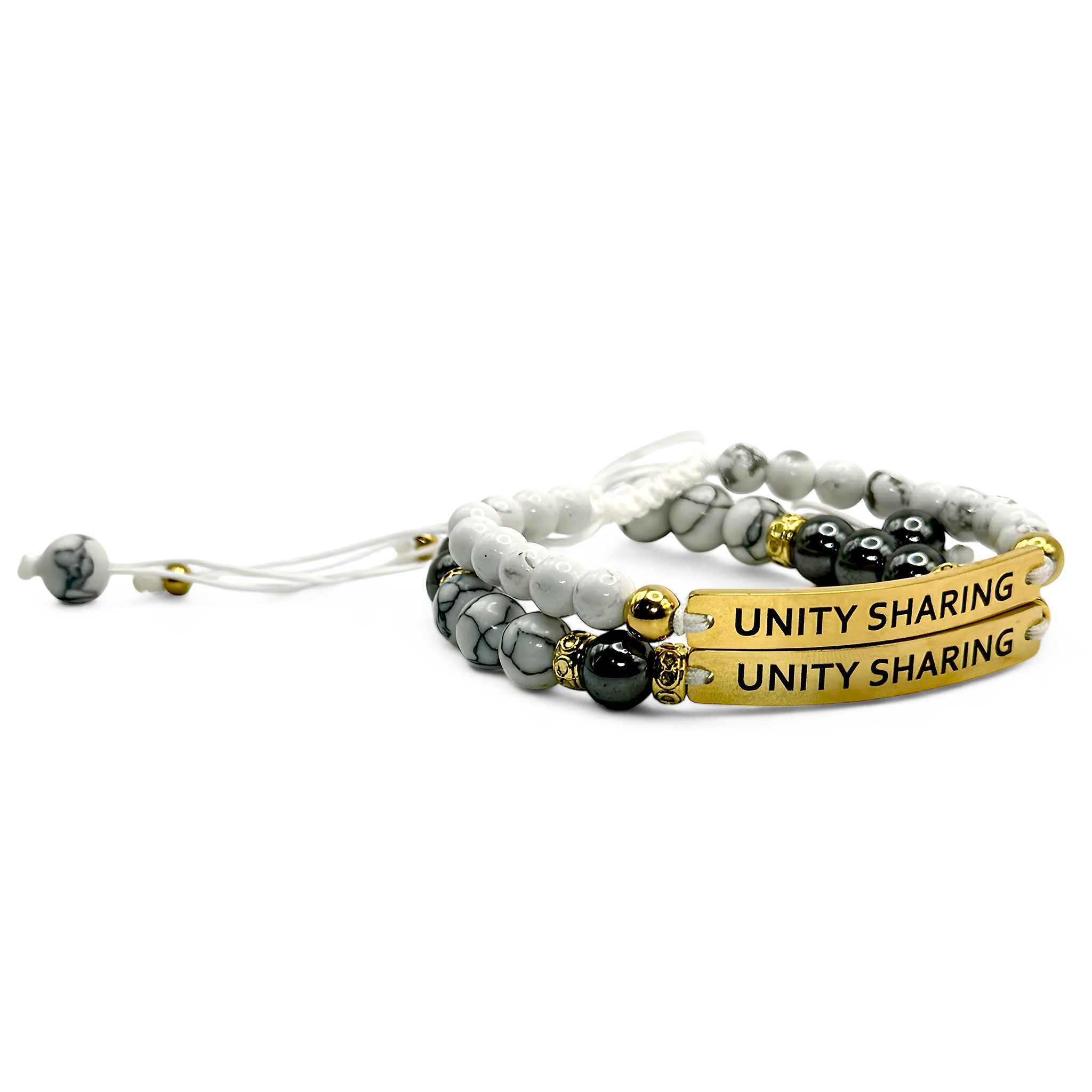Set of two white beaded bracelets with gold and silver-tone bars engraved “UNITY SHARING” — neutral and stackable bundle.

